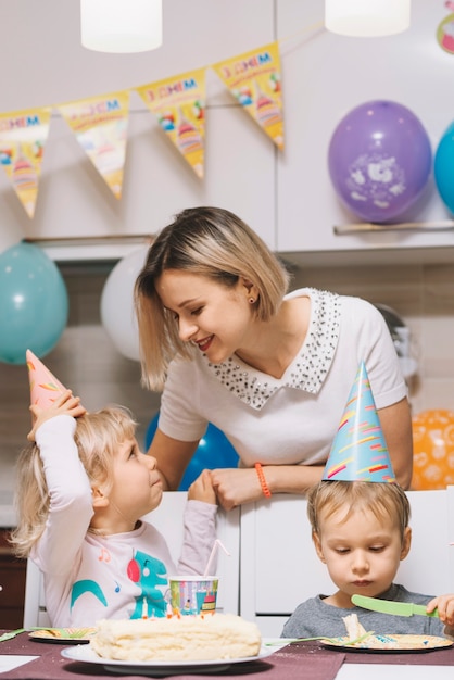 Moeder met kinderen op verjaardagsfeestje