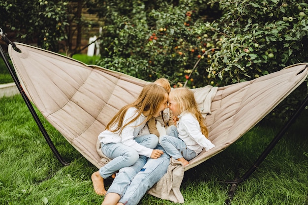 Moeder met kinderen plezier in een hangmat. moeder en kinderen in een hangmat.