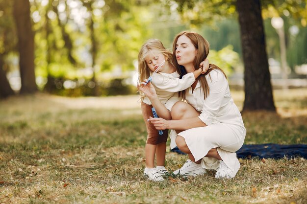 Moeder met kleine dochter die in een de zomerpark speelt