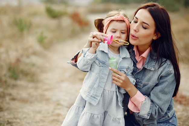 Gratis foto moeder met kleine dochter die op een gebied speelt