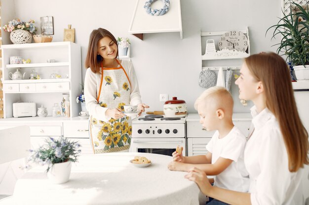 Moeder met kleine kinderen die thee thuis drinken