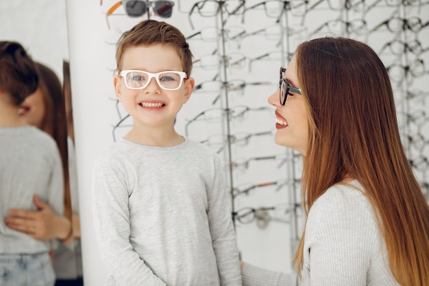 Moeder met kleine zoon in de bril winkel