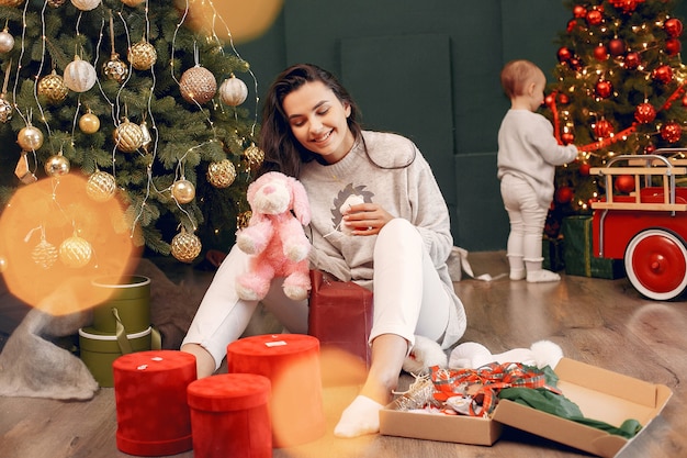 Moeder met schattige dochter in de buurt van de kerstboom