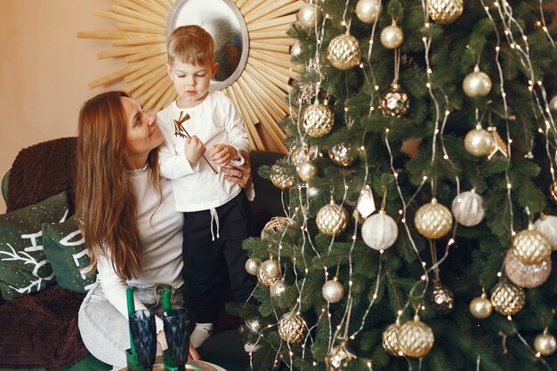 Moeder met schattige zoon in de buurt van kerstboom
