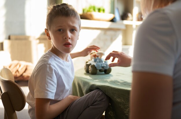 Moeder speelt met haar autistische zoon met behulp van speelgoed