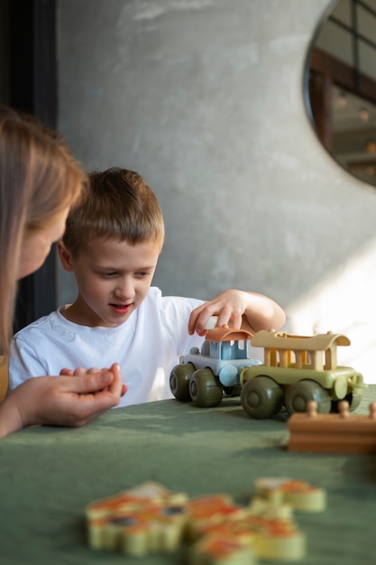 Moeder speelt met haar autistische zoon met behulp van speelgoed