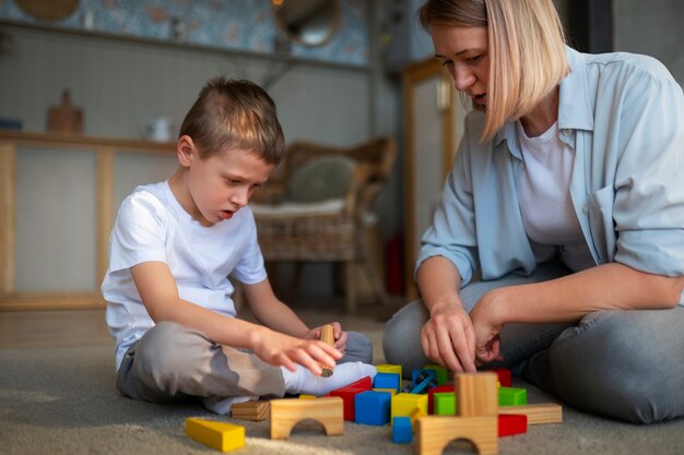 Moeder speelt met haar autistische zoon met behulp van speelgoed