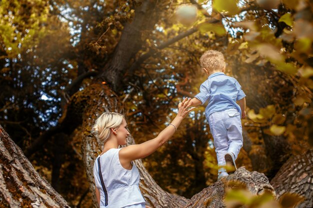 Moeder speelt met haar kind op boom in het park.