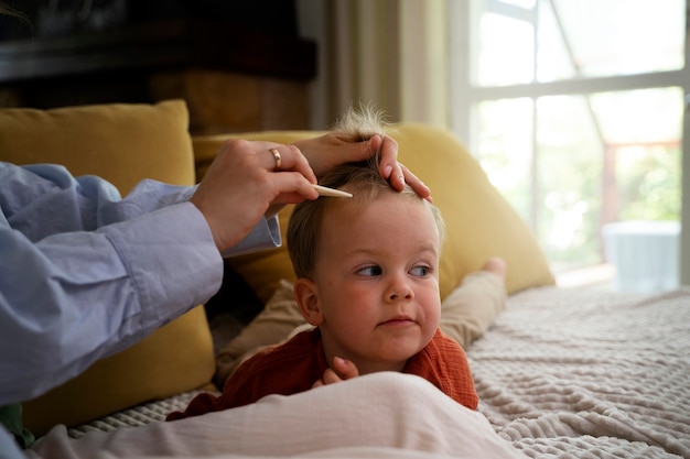 Gratis foto moeder zorgt voor haar kind met luizen