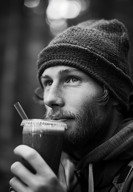 Gratis foto monochroom portret van een man die een gezonde smoothie drinkt