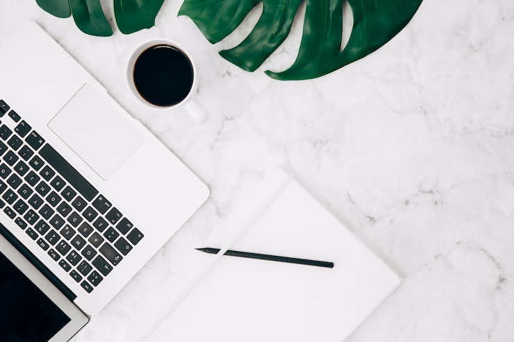 Gratis Foto monstera-blad; koffie; laptop; potlood en dagboek op marmeren gestructureerde achtergrond