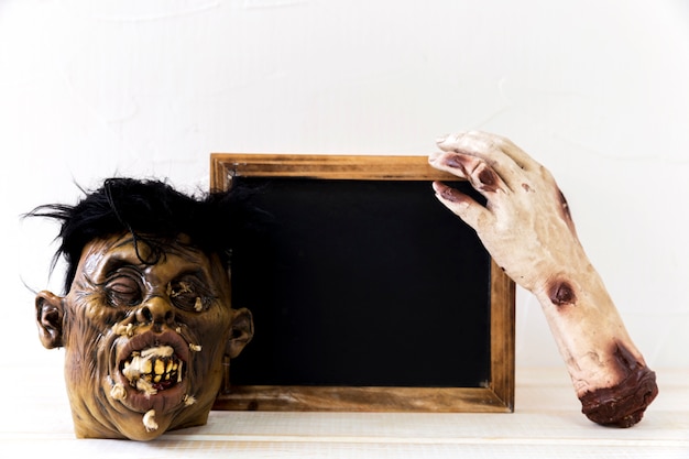 Monsterhand en masker dichtbij bord