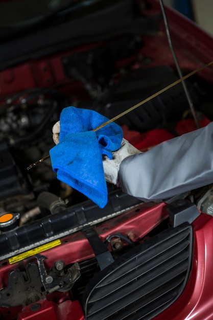 Gratis foto monteur het controleren van het oliepeil in een automotor