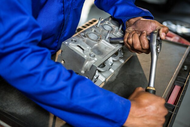 Monteur repareren onderdeel van de motor met pal aan de reparatie garage