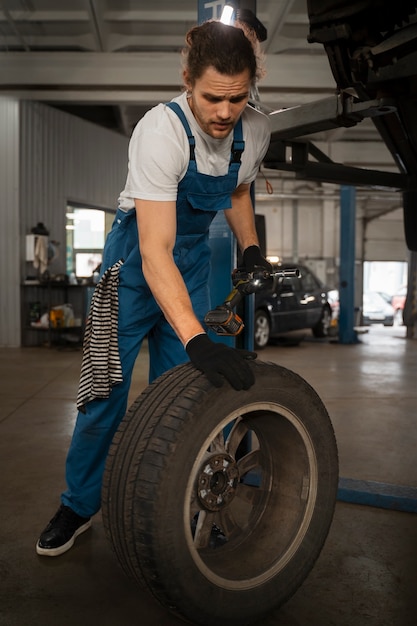 Gratis foto monteur werkt in de winkel aan een auto