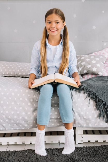 Gratis foto mooi blij meisje poseren met een boek
