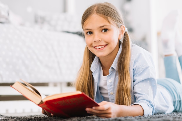 Gratis foto mooi blij meisje poseren met een boek