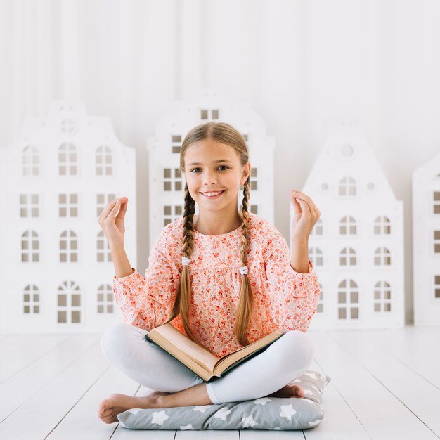 Gratis foto mooi blij meisje poseren met een boek