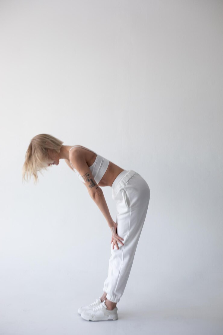 Mooi blond meisje in een witte top en collets poseert op een witte achtergrond