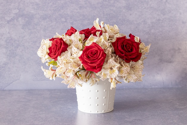 Mooi boeket met rode rozen en leliebloemen in een doos
