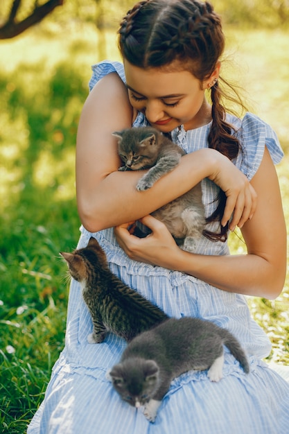 Gratis foto mooi en schattig meisje in blauwe jurken met mooie kapsels en make-up zitten