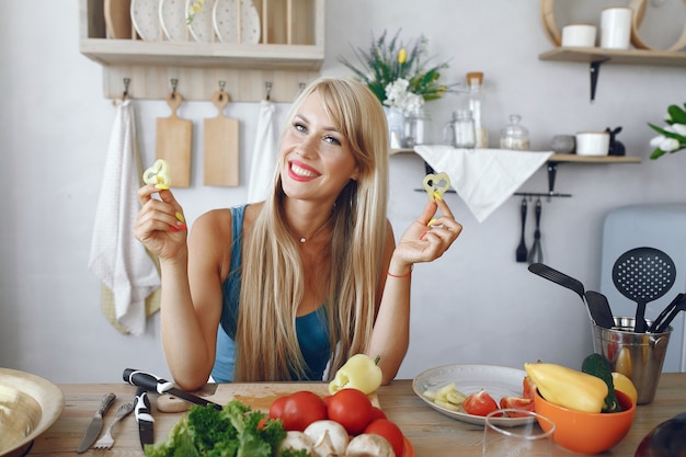 Mooi en sportief meisje in een keuken met groenten