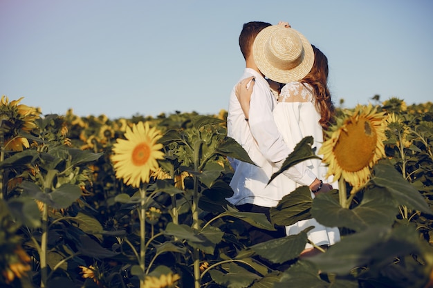 Mooi en stijlvol paar in een veld met zonnebloemen