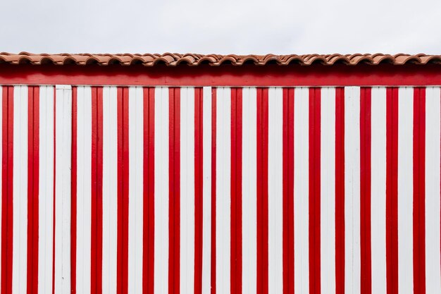 Mooi gekleurd huis met een creatieve muur met witte en rode lijnen op het strand in portugal