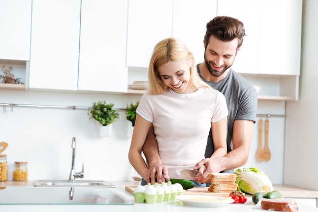 Mooi glimlachend paar samen koken in een moderne keuken