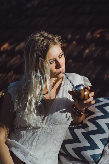 Mooi Indisch hippiemeisje met lang blond haar op de dak het drinken partnerthee.