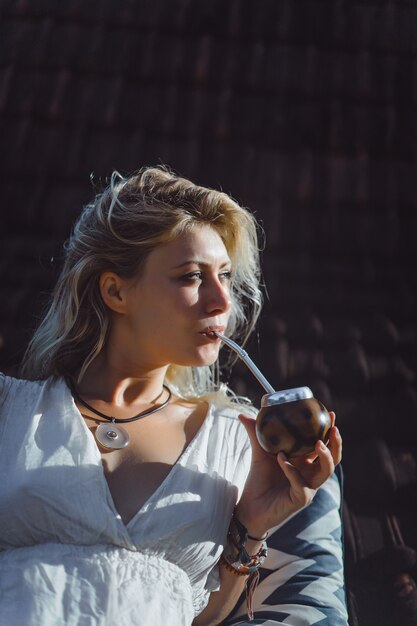 Mooi Indisch hippiemeisje met lang blond haar op de dak het drinken partnerthee.