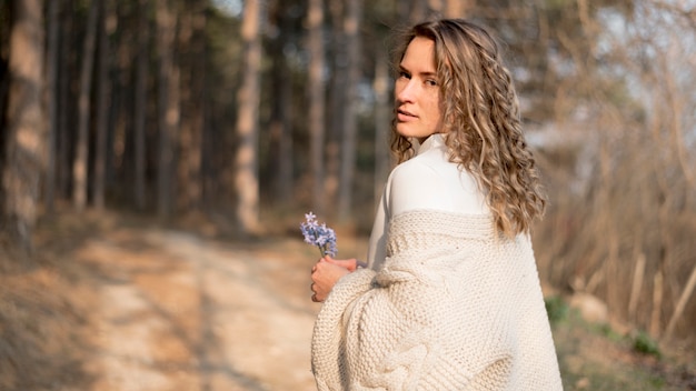 Gratis foto mooi jong meisje met krullend haar met een bloem