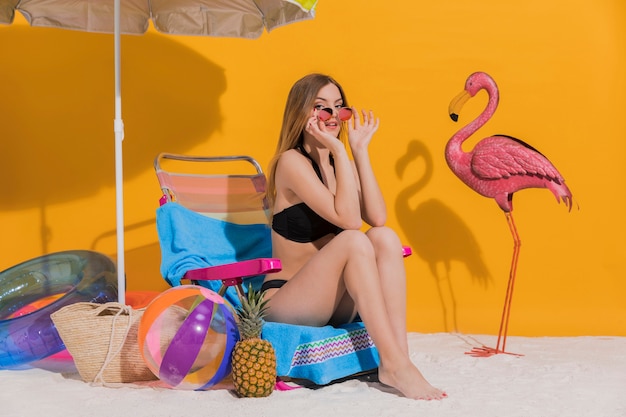 Gratis foto mooi jong wijfje in bikinizitting op daybed in studio