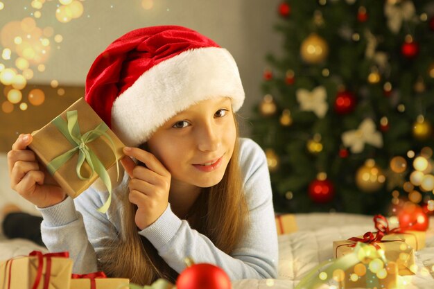 Mooi klein meisje in een goed humeur met cadeaus in het kerstinterieur