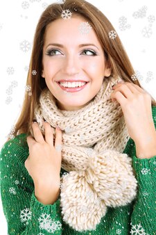 Mooi lachend meisje in warme gebreide sjaal geïsoleerd op wit