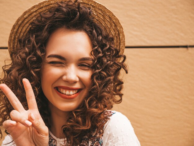 Mooi lachende model met afro krullen kapsel gekleed in zomer hipster witte jurk.