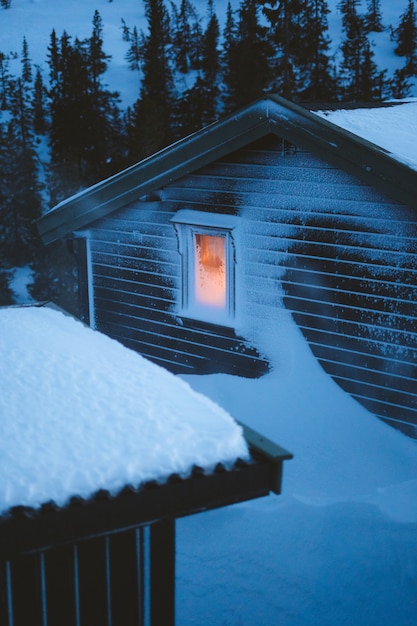 Mooi landschap van dorp met houten hutten bedekt met sneeuw, omringd door sparren in Noorwegen