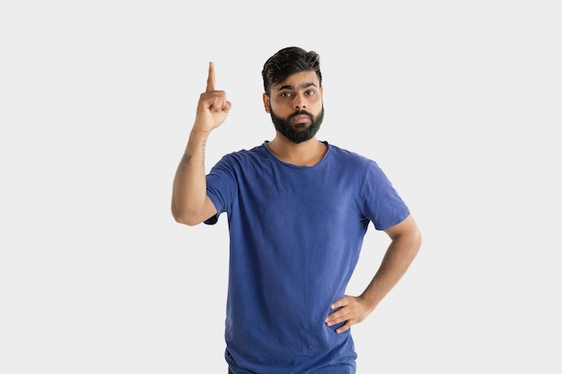 Mooi mannelijk geïsoleerd portret. Jonge emotionele hindoe man in blauw shirt. Gelaatsuitdrukking, menselijke emoties. Wijzen en kiezen.