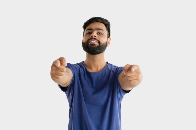 Mooi mannelijk geïsoleerd portret. Jonge emotionele hindoe man in blauw shirt. Gelaatsuitdrukking, menselijke emoties. Wijzen en kiezen.