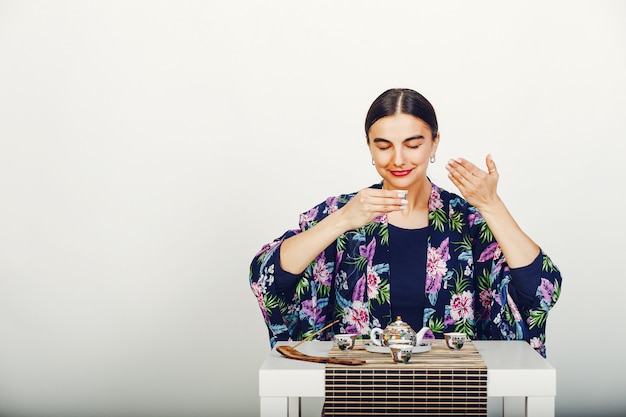 Mooi meisje dat een thee in een studio drinkt