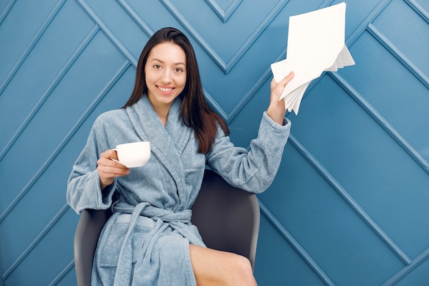 Mooi meisje dat zich in een studio in een blauwe badjas bevindt