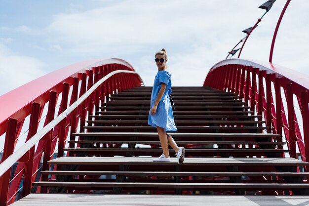 mooi meisje in een blauwe jurk die zich voordeed op de brug