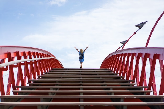 mooi meisje in een blauwe jurk die zich voordeed op de brug