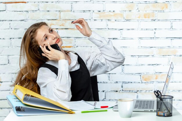 Mooi meisje in schooluniform praten aan de telefoon