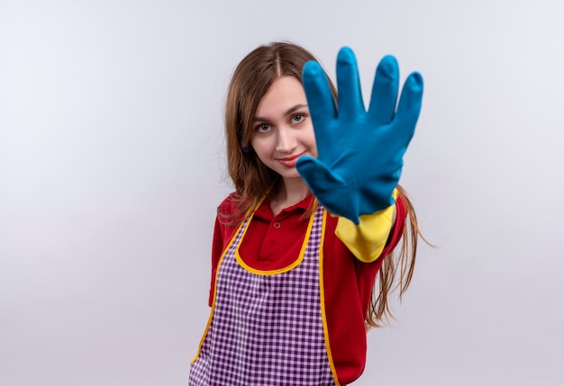 Mooi meisje in schort en rubberen handschoenen met open hand stopbord maken