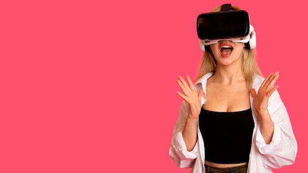 Gratis foto mooi meisje in vr-bril op een roze achtergrond in virtual reality