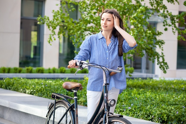 Mooi meisje met een fiets op de weg