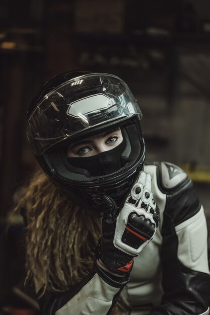 mooi meisje met lang haar in de garage die een motorfiets herstelt