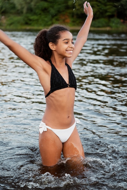 Gratis foto mooi meisje met plezier buiten aan het meer