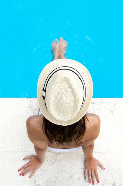 Mooi meisje ontspannen bij het zwembad in de zomer